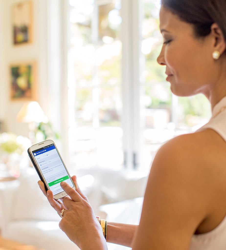 Woman with smart phone   booking appointment on Pillar to Post website