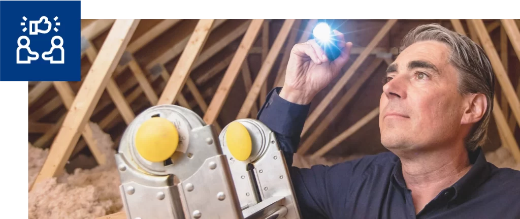 Technician holding flashlight on ladder