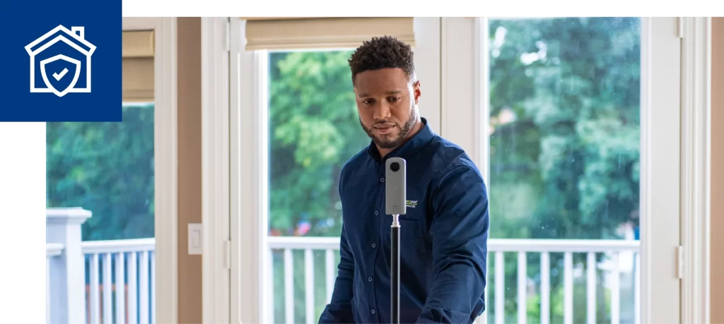 Technician using a 360 camera to conduct a home inspection inside a bright living space